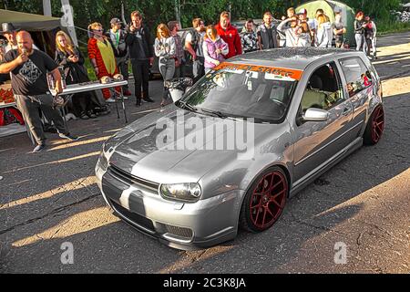 Moskau, Russland - 19. Juli 2019: Getuntes Low-Sport-Fließheck mit roten Candy-farbigen Leichtmetallfelgen. Volkswagen Golf mk 4 ist auf der Straße. Stanced Lowrider mit Badboy Kapuze Stockfoto