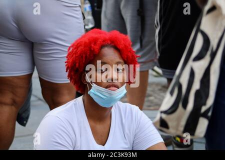 Washington D.C., District of Columbia, USA. Juni 2020. Schwarze Frau mit roten Haaren und blauer Maske hört Musik und Protestrede während der Juneteenth-Kundgebung im Freedom Square, Washington, DC Credit: Amy Katz/ZUMA Wire/Alamy Live News Stockfoto