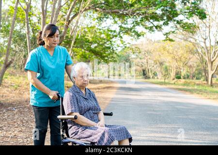 Krankenschwester Hilfe und Pflege Asian Senior oder ältere alte Dame Frau Patient sitzt auf Rollstuhl im Park in Krankenpflege-Station: Gesunde starke medizinische con Stockfoto