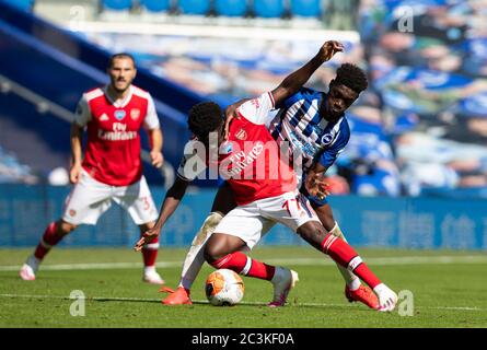 Brighton. Juni 2020. Arsenals Bukayo Saka (C) steht mit Brighton und Hove Albions Yves Bissouma (R) während des Premier League-Spiels zwischen Brighton und Hove Albion und Arsenal FC im American Express Community Stadium in Brighton, Großbritannien, am 20. Juni 2020. Quelle: Xinhua/Alamy Live News Stockfoto