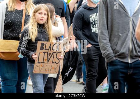 Saint John, NB, Kanada - 14. Juni 2020: Eine junge kaukasische Teenager trägt ein Black Lives Matter Zeichen, während sie in einer Kundgebung marschiert. Stockfoto