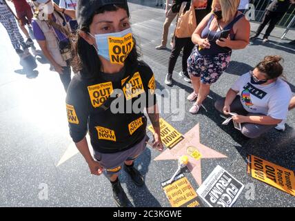 Los Angeles, Kalifornien, USA. Juni 2020. Ein Demonstrator mit einer Maske mit 'Trump/Pence OUT NOW' steht neben Donald Trumps Star auf dem Hollywood Walk of Fame, während Demonstranten am Samstag, den 20. Juni 2020, in Los Angeles gegen Präsident Trump und Vizepräsident Pence White House demonstrieren. Kredit: Ringo Chiu/ZUMA Wire/Alamy Live Nachrichten Stockfoto