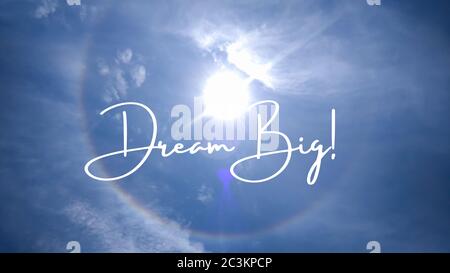 Inspirierendes Zitat geschrieben auf einem bewölkten Himmel mit einem Regenbogen. Nachricht mit dem Satz Traum groß. Nachricht oder Karte. Konzept der Inspiration. Positive Phras Stockfoto