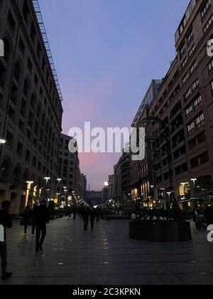 Vertikale Aufnahme von Menschen, die während des Sonnenuntergangs in der nördlichen Allee von Jerewan, Armenien, spazieren gehen Stockfoto