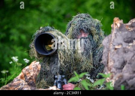 Wildlife Fotograf im Sommer Ghillie Camouflage Anzug arbeiten in der Wildnis Stockfoto