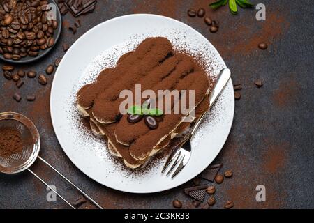 Klassisches Tiramisu Dessert auf Keramikplatte auf Betongrund Stockfoto