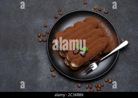 Klassisches Tiramisu Dessert auf Keramikplatte auf Betongrund Stockfoto