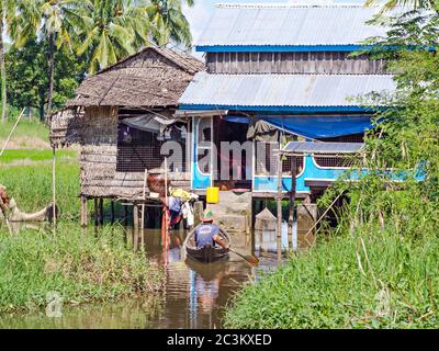 Maubin, MYANMAR - 12. NOVEMBER 2014: Mann kehrt zu seiner Farm in Maubin, Ayeyarwady Division im Südwesten von Myanmar zurück. Viele Häuser in der Gegend fehlen r Stockfoto