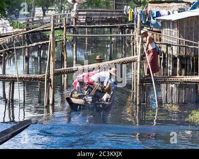 Maubin, MYANMAR - 12. NOVEMBER 2014: Kanalfähre unter einer niedrigen Brücke in Maubin, Ayeyarwady Division im Südwesten von Myanmar. Viele Häuser in den sind Stockfoto