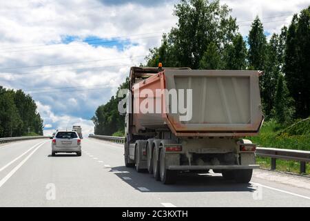 Ein schmutziger LKW fährt Waren in ein anderes Land entlang der Autobahn. Konzept von Export-Import, Transport, nationale Lieferung von Waren Stockfoto