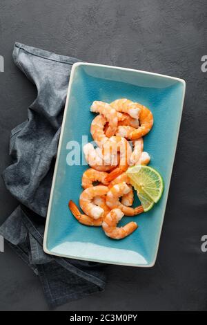 Meeresfrüchte. Gekochte Garnelen in einem Teller auf schwarzem Hintergrund. Draufsicht. Stockfoto