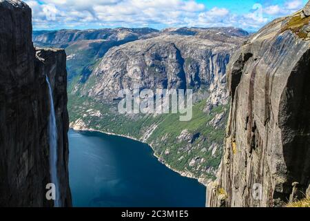 Luftaufnahme von Lysefjord aus Kjeragbolten, mit Wasserfall auf dem Felsen und Berge im Hintergrund, auf dem Berg Kjerag in Forsand Kommune Stockfoto