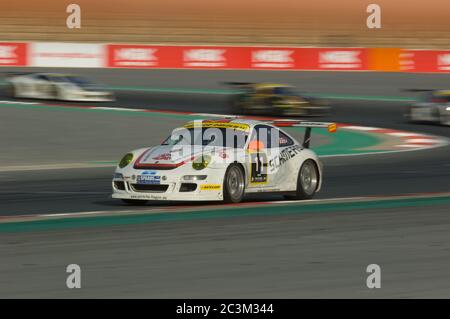 DUBAI - JANUAR 13: Car 11, ein Porsche 997 GT3 Cup S, nimmt am 2012 13. Januar 2012 am Dunlop 24-Stunden-Rennen auf dem Dubai Autodrome Teil. Stockfoto