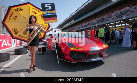 DUBAI - JANUAR 13: Umbrella girl und Lamborghini Gallardo LP600 am Start vor dem Dunlop 24-Stunden-Rennen 2012 auf dem Dubai Autodrome am 1. Januar Stockfoto