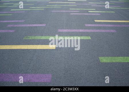 Gelbe, grüne und violette Linien auf dem Asphaltboden gemalt Stockfoto