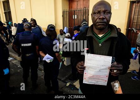 Die südafrikanische Polizei verhängt Geldstrafen gegen obdachlose ausländische Flüchtlinge aus Afrika wegen Verstoßes gegen die Gesetze auf Wiedersehen in Kapstadt während des Ausbruchs des Coronavirus Stockfoto