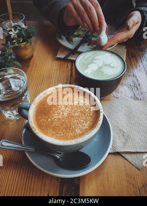 Vertikale Aufnahme von zwei Tassen Kaffee in einem hohen Winkel Ein Holztisch Stockfoto