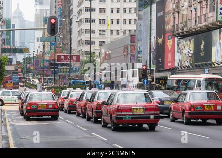 HONGKONG - MAI 13: Klassische, rote Toyota Crown Taxis warten am 13. Mai 2012 an einer Ampel in Kowloon in Hongkong. Stockfoto