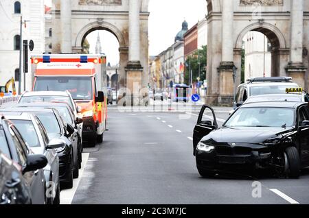 München, Deutschland. Juni 2020. Ein Auto, das während der Fahrt die Kontrolle verloren hat und einen Unfall verursacht hat, parkt neben einem Krankenwagen vor dem Siegestor in der Leopoldstraße. Quelle: Felix Hörhager/dpa/Alamy Live News Stockfoto