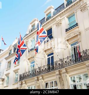 Britische Flaggen fliegen auf dem Balkon eines historischen Gebäudes im Zentrum von London Stockfoto