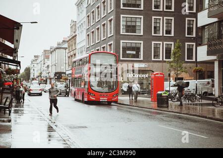 London, Großbritannien - 18. August 2017: Die Straßen von London während des Regens. Rote Telefonzellen und rote londoner Busse. Stockfoto