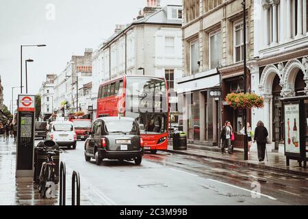 London, Großbritannien - 18. August 2017: Die Straßen von London während des Regens. Rote Telefonzellen und rote londoner Busse. Sommer in London Stockfoto