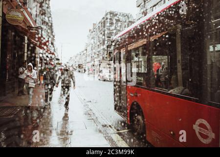 London, Großbritannien - 18. August 2017: Die Straßen von London während des Regens. Rote Telefonzellen und rote londoner Busse. Sommer in London Stockfoto