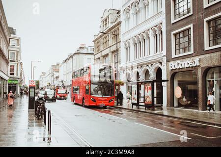 London, Großbritannien - 18. August 2017: Die Straßen von London während des Regens. Rote Telefonzellen und rote londoner Busse. Sommer in London Stockfoto