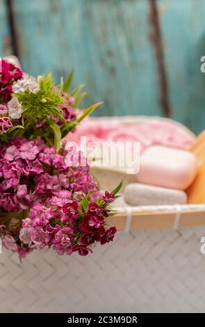 Spa-Accessoires in einem Korb auf einem Holztisch Stockfoto