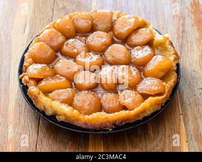 Hausgemachten Apfelkuchen Tarte Tatin auf schäbigen Holztisch in der heimischen Küche Stockfoto