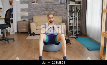 Fitt Mann Training abs Muskel auf schweizer Ball in zu Hause. Stockfoto