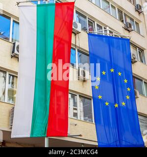 Bulgarische Nationalflagge und EU-Flagge hängen an einem Bürogebäude in der Stadt Sofia, Bulgarien Stockfoto