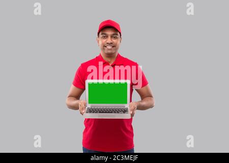 Delivery Man Zeigt Laptop Green Screen. Home-Bestellungen, Quarantäne-Lieferung, Online-Shopping, Freiberufler-Konzept. Stockfoto
