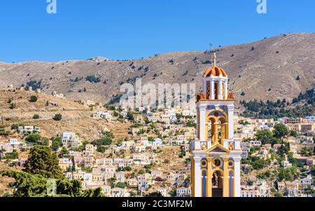 Der Glockenturm der Verkündigung-Kirche mit Blick auf den alten Hügel Horio, Symi Island, Dodekanes, Griechenland Stockfoto