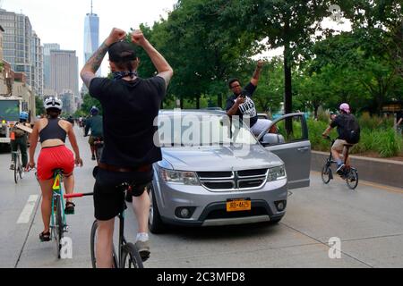 New York, NY, 20. Juni 2020. Eine Frau im Auto hebt ihre Faust, während Tausende von Demonstranten auf Fahrrädern am West Side Highway vorbeifahren. Der Fahrradprotest war eine Solidaritätsfahrt mit Black Lives Matter, die in einer Reihe von amerikanischen Polizeimorden Gerechtigkeit forderte: George Floyd, Breonna Taylor und unzählige andere. Die Fahrradtour wurde von dem Kollektiv Street Riders NYC organisiert. Mehrere tausend Menschen nahmen an der bewegenden Demonstration Teil, die vom Times Square, Harlem und Battery Park aus ging. Juni 20, 2020 Stockfoto