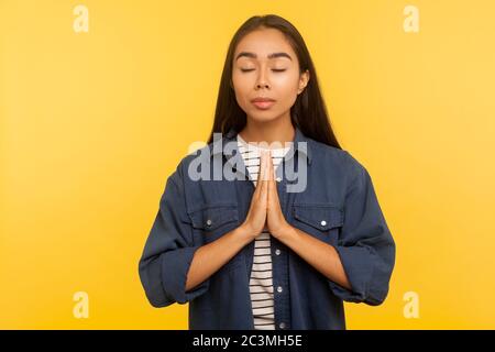 Friedvoller Geist. Portrait von Mädchen in Denim-Shirt meditieren mit namaste Geste und Gefühl Harmonie Gleichgewicht, Pause zu entspannen, konzentrieren Gedanken Stockfoto