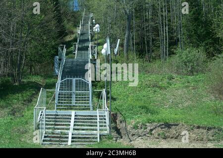 Steile Metalltreppe führt zum Gipfel des Waldwanderweges Stockfoto