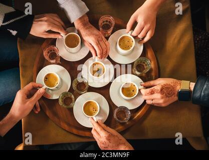 Gruppe von Menschen mit Henna Mehndi Tattoo auf den Händen trinken türkischen coffey, Draufsicht Stockfoto