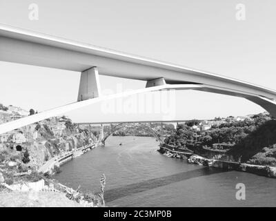 Graustufen Aufnahme einer Brücke über das Wasser unter Ein wolkenverdeckter Himmel Stockfoto