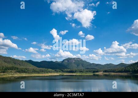 See mit grünen Bergkette in bewölktem blauen Himmel Tag Stockfoto