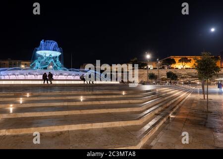 Platz mit dem Tritons-Brunnen (maltesisch: Il-Funtana tat-Tritoni) bei Nacht und Valletta City Skyline in Malta Stockfoto