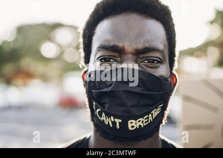 Junger schwarzer Mann mit Gesichtsmaske während der Gleichberechtigung Protest - Konzept der Demonstranten auf der Straße für Black Lives Matter und ich kann nicht atmen Kampagne - Stockfoto