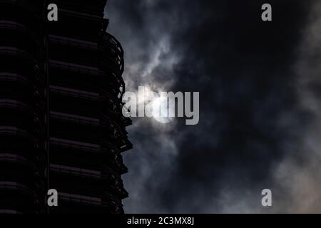 Kuala Lumpur, Malaysia. Juni 2020. Eine partielle Sonnenfinsternis wird in der Nähe der Petronas Twin Towers in Kuala Lumpur, Malaysia, am 21. Juni 2020 gesehen. Quelle: Zhu Wei/Xinhua/Alamy Live News Stockfoto