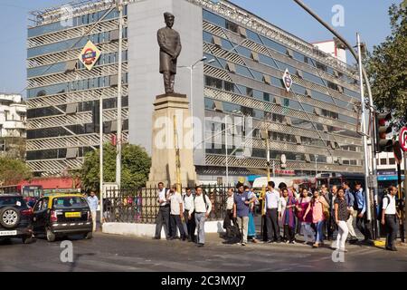 Eine Statue des Parsi-Politikers Sir Dinshaw Edulji Wacha (1844–1936) und Pendler an der Churchgate Station (Western Railway), Churchgate, Mumbai, Indien Stockfoto