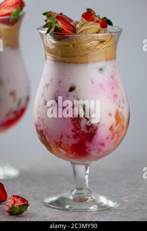 Kalter Sommerdessert. Schalen aus Gelee mit mehreren Schichten auf dem Tisch vor hellem Hintergrund serviert. Farbenfroher, festlicher Cocktail mit Süßwaren Gelee im Glas Stockfoto