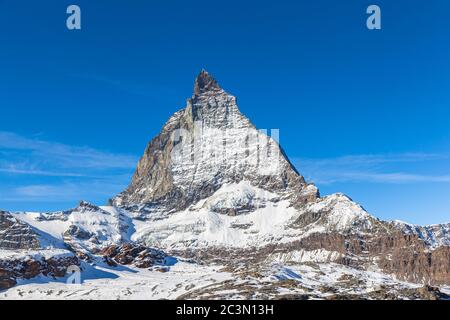 Atemberaubende Nahaufnahme des berühmten Matterhorn-Gipfels der Schweizer Alpen an sonnigen Herbsttag mit Schnee und blauer Himmelswolke, von der Seilbahn Trockener S Stockfoto