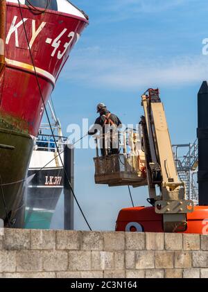 15. Juni 2020. Fraserburgh Harbour, Aberdeenshire, Schottland, Großbritannien. Dies ist ein Mann Spray Reinigung und Waschen einer Sea Fishing Trawler in einem Trockendock. Stockfoto