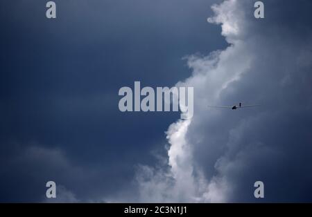 Kaufbeuren, Deutschland. Juni 2020. Ein vor den Wolken fliegender Segelflieger wird von der Sonne beleuchtet. Quelle: Karl-Josef Hildenbrand/dpa/Alamy Live News Stockfoto