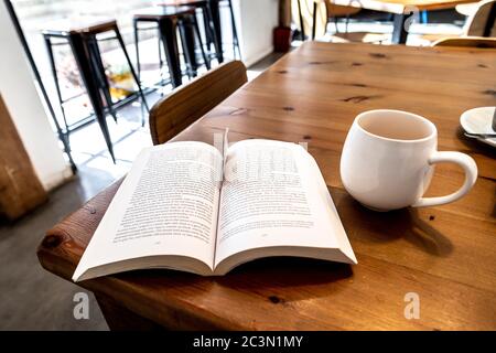 Buch und eine Tasse Tee auf einem Tisch in einem Café Stockfoto