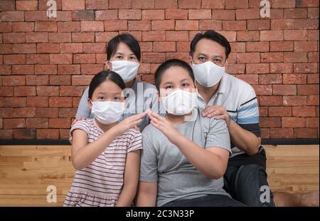 Asiatische Familie trägt Gesichtsmasken während Coronavirus und Grippe Ausbruch. Schutz vor Viren und Krankheiten, Quarantäne. COVID-2019. Ein Anruf, um zu Hause zu bleiben Stockfoto